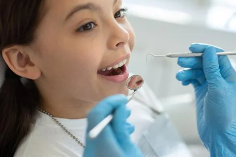 Close up of small client at dental procedure, dentist using dental instrument Stock Photos