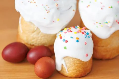 Close-up of small Easter paska cake with white icing and red eggs Stock Photos