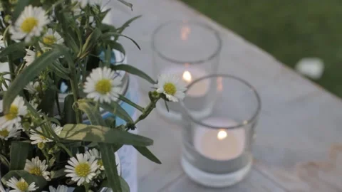 Close Up of Small Flower Daisy and Candles on a exterior outdoor table Stock Footage 142012414