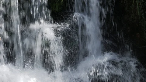 Close up small forest waterfall cascading over mossy rocks Stock Footage 111741627