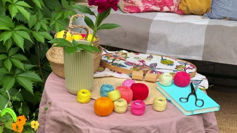 Close-up of a small garden table with embroidery supplies on a warm summer day.  Stock Footage 311475542