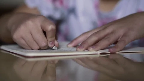 Close up of small girl hands erasing notes with rubber on white paper sheet Stock Footage