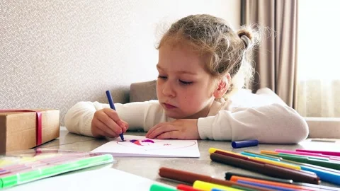 Close-up of small hands holding pencil creating childish artwork. Kid Stock Footage 308386679