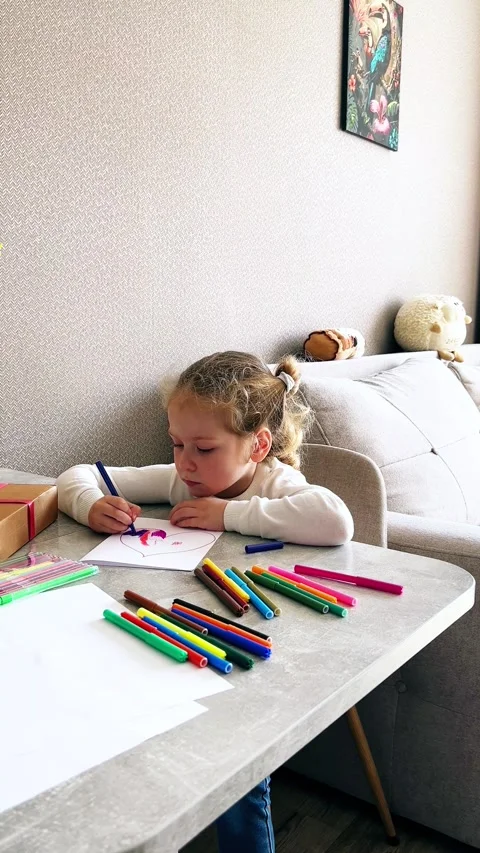 Close-up of small hands holding pencil creating childish artwork. Kid spends Stock Footage 311572079