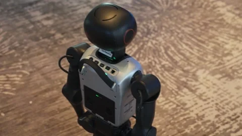 Close up of small humanoid robot nodding and greeting visitors at tech event Stock Footage 323368071