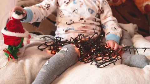 Close-up small kid boy plays with christmas balls and garland .Magic vibe of new Stock Footage 219480179