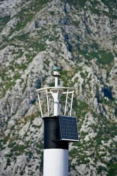 Close-up of Small Lighthouse Top Against Rocky Mountain Stock Photos