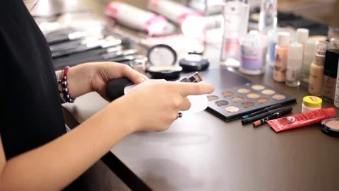 Close up of small makeup brush moving over brown eye shadows Stock Footage 86416472