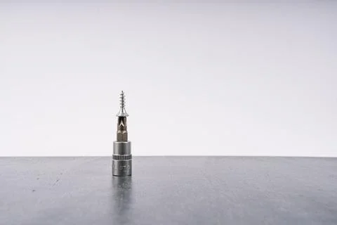 Close-up of a small metal drill bit on a gray surface Stock Photos