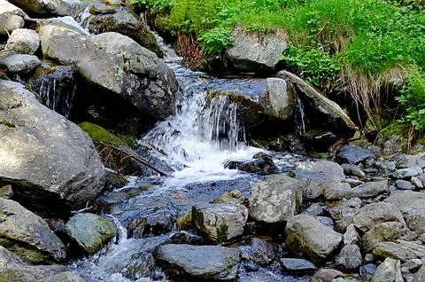 Close-Up of Small Mountain Waterfall and Fast Flowing River Through Rocks Stock Photos