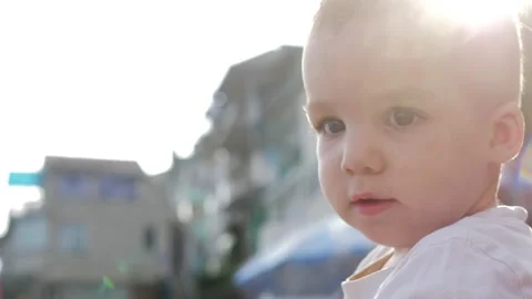 Close-up, A small one-year-old boy is sitting by the sea on a bright sunny day Stock Footage 159571976