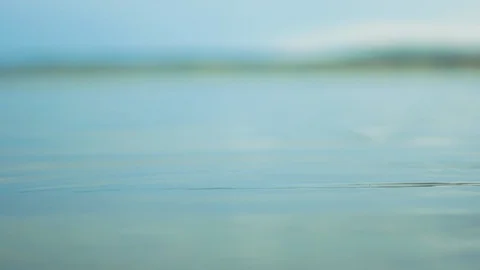 Close up of a small pebble dropping in water causing small splashes and ripples  Stock Footage 116688368