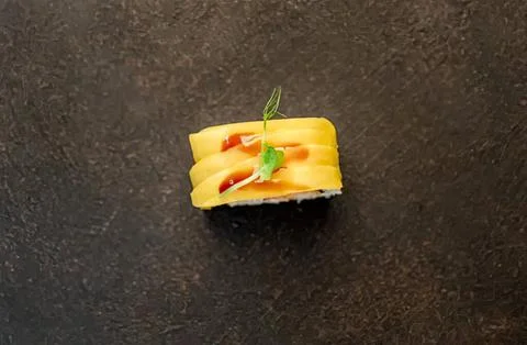 Close-up of a small pineapple slice with sauce and a leaf 写真素材
