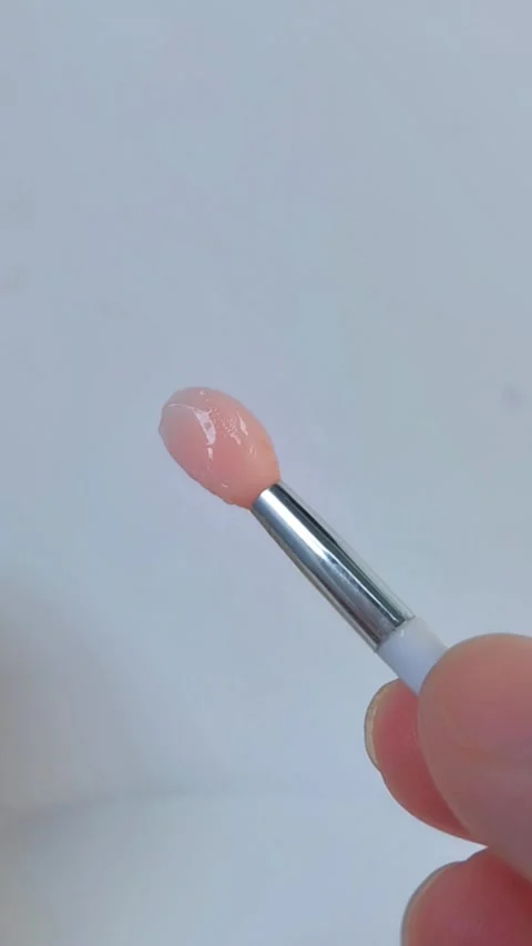 Close up of a small pink brush tip coated with shimmering beauty serum. Stock Footage 330080446