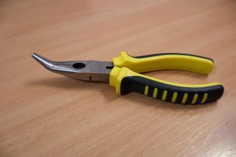 Close up of small pliers on table surface. Stock Photos