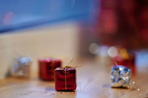 Close-up of small red decorative gift box with golden ribbon on wooden surfac Stock Photos