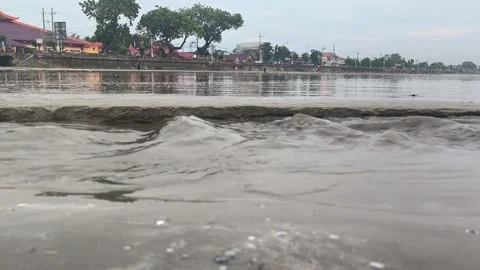 Close up of a small river with the soil on its banks being eroded by water Stock Footage 329401530