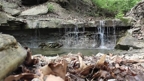 Close-Up of a Small Scenic Waterfall Over Dark Rocks Video stock 333416940