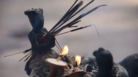 Close up: Small statue holding prayer offering incense burning - Nepal Stock Footage 79856935