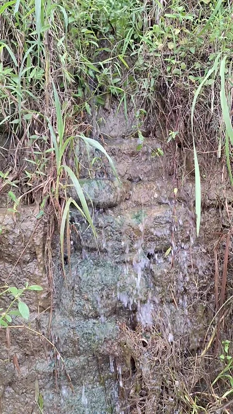 Close up of small stream flowing through muddy rocks Stock Footage 337051166