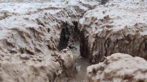 Close up of a small stream of water destroying the ground Stock-Footage 247734613