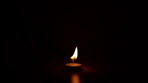 Close up of a small tea light candle flame flickering gently in darkness. Stock Footage 332749939