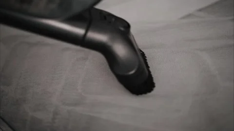 Close up of a small vacuum cleaning a grey couch Stock Footage 290337337