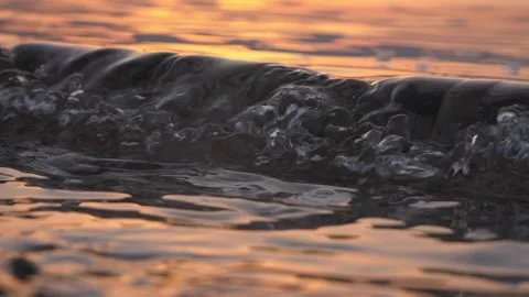 Close up of a small water wave during warm sunset. Stock Footage 337407993