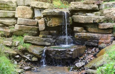 Close up of a small waterfall spilling over moss covered rocks in regional park Fotos de archivo