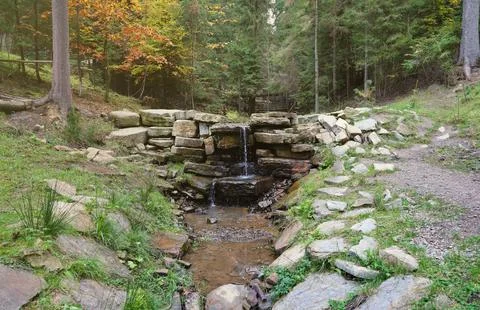 Close up of a small waterfall spilling over moss covered rocks in regional park Fotos de archivo