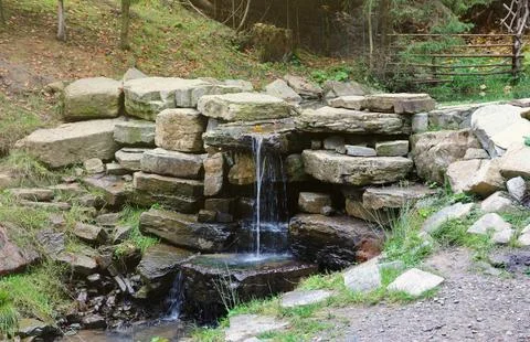 Close up of a small waterfall spilling over moss covered rocks in regional park Fotos de archivo