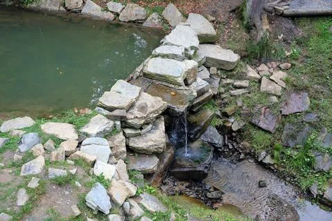 Close up of a small waterfall spilling over moss covered rocks in regional park Fotos de archivo