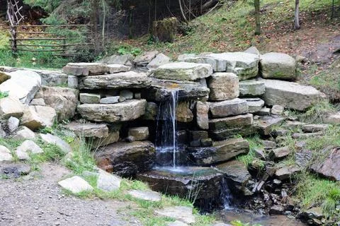 Close up of a small waterfall spilling over moss covered rocks in regional park Fotos de archivo