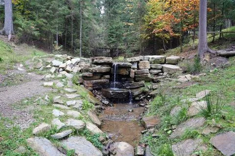 Close up of a small waterfall spilling over moss covered rocks in regional park Fotos de archivo