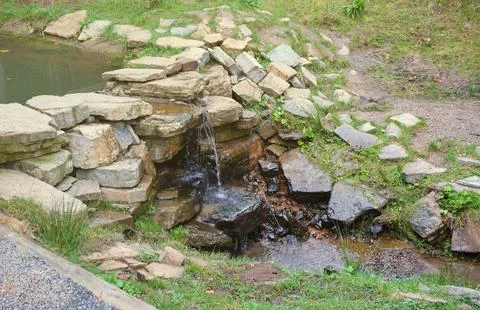 Close up of a small waterfall spilling over moss covered rocks in regional park Fotos de archivo
