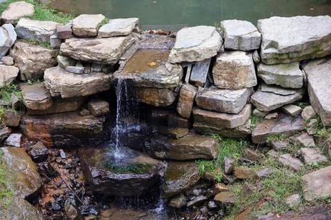 Close up of a small waterfall spilling over moss covered rocks in regional park Fotos de archivo