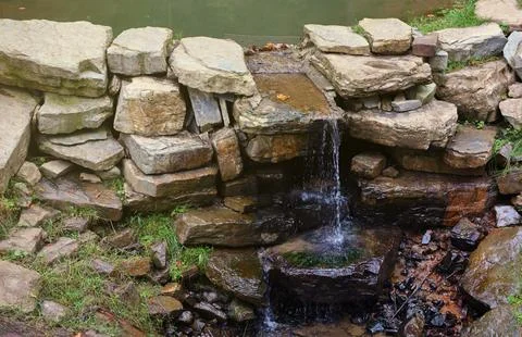 Close up of a small waterfall spilling over moss covered rocks in regional park Fotos de archivo