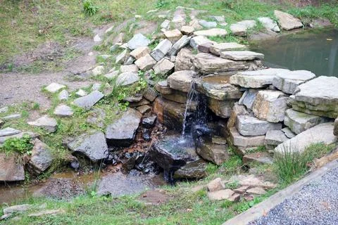Close up of a small waterfall spilling over moss covered rocks in regional park Fotos de archivo