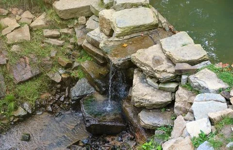 Close up of a small waterfall spilling over moss covered rocks in regional park Fotos de archivo
