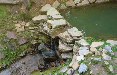 Close up of a small waterfall spilling over moss covered rocks in regional park Fotos de archivo