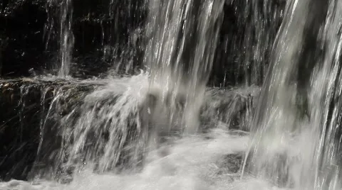 Close up of a small waterfall, water flowing over rocks Stock Footage 41744979
