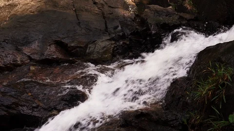 Close up of a small waterfall with water splashing at the stone Video stock 93135436