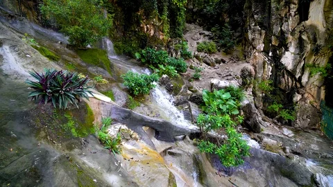 Close up of a small waterfall with water splashing at the stone at Malaysia Stock Footage 93910982