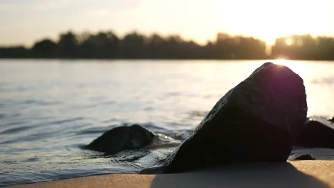Close up small waves against the stones on de river at sunset. Stock Footage 136880735