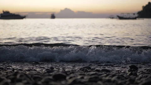 Close up of small waves crushing at beach at sunset with horizon in background Stockbeeldmateriaal 277377969