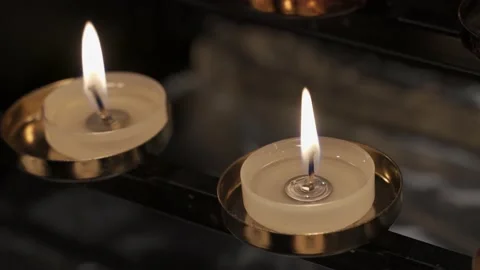 Close up of small wax candles burning in a church dark background 스톡 동영상 132344842