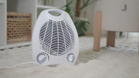 Close up on small white fan heater on fluffy carpet gentle motion background. Video stock 331835852