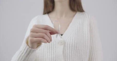 Close up of a small white ribbon in the hands of a girl with a delicate manicure Vídeo Stock 147725555