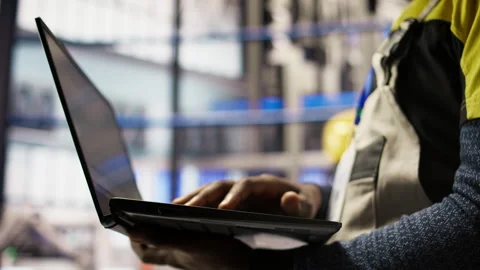 Close up of smart factory worker using laptop to test automated systems Stock Footage 307361843