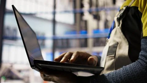 Close up of smart factory worker using laptop to test automated systems Stock Photos